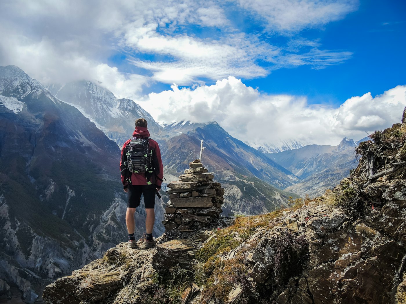 Una persona con mochila mira las montañas